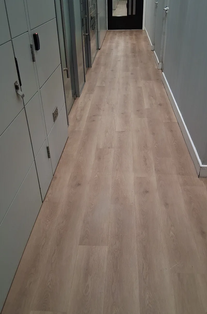 Oak-effect plank flooring along a long office corridor